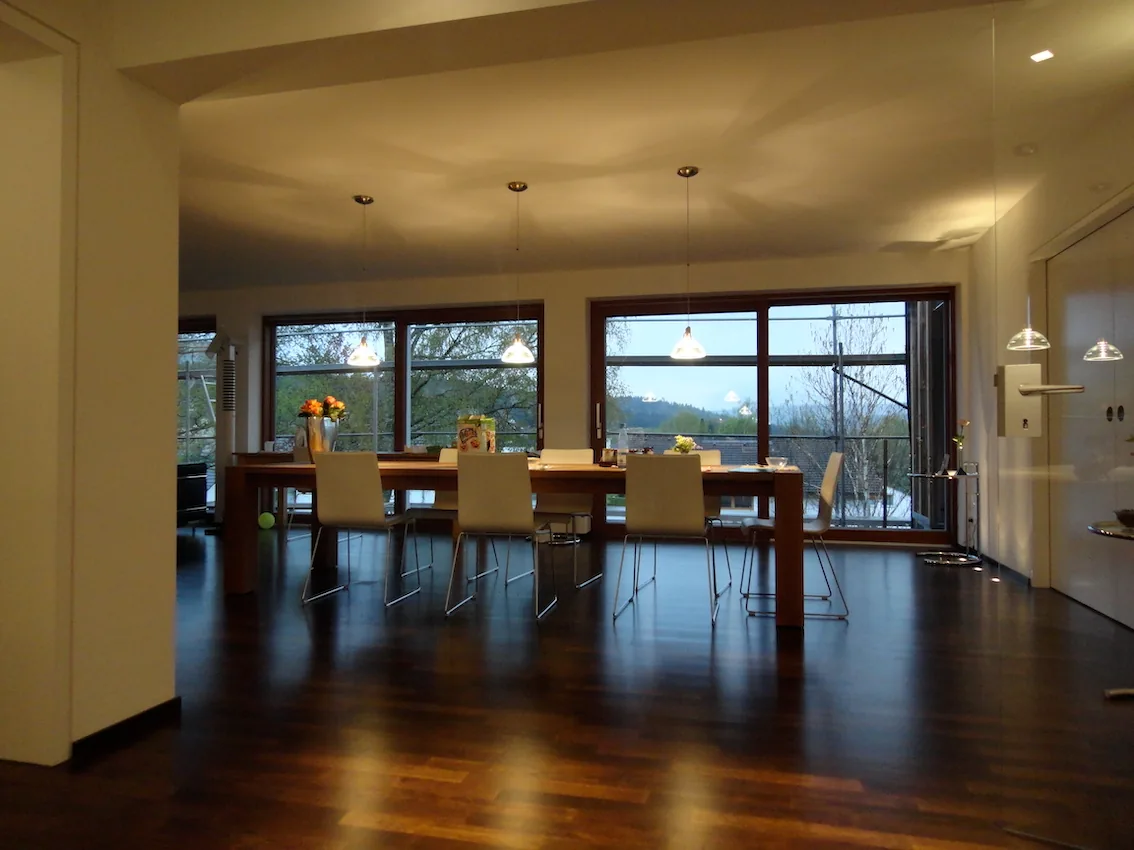 Essbereich mit langem Tisch und Fensterfront, Innenansicht