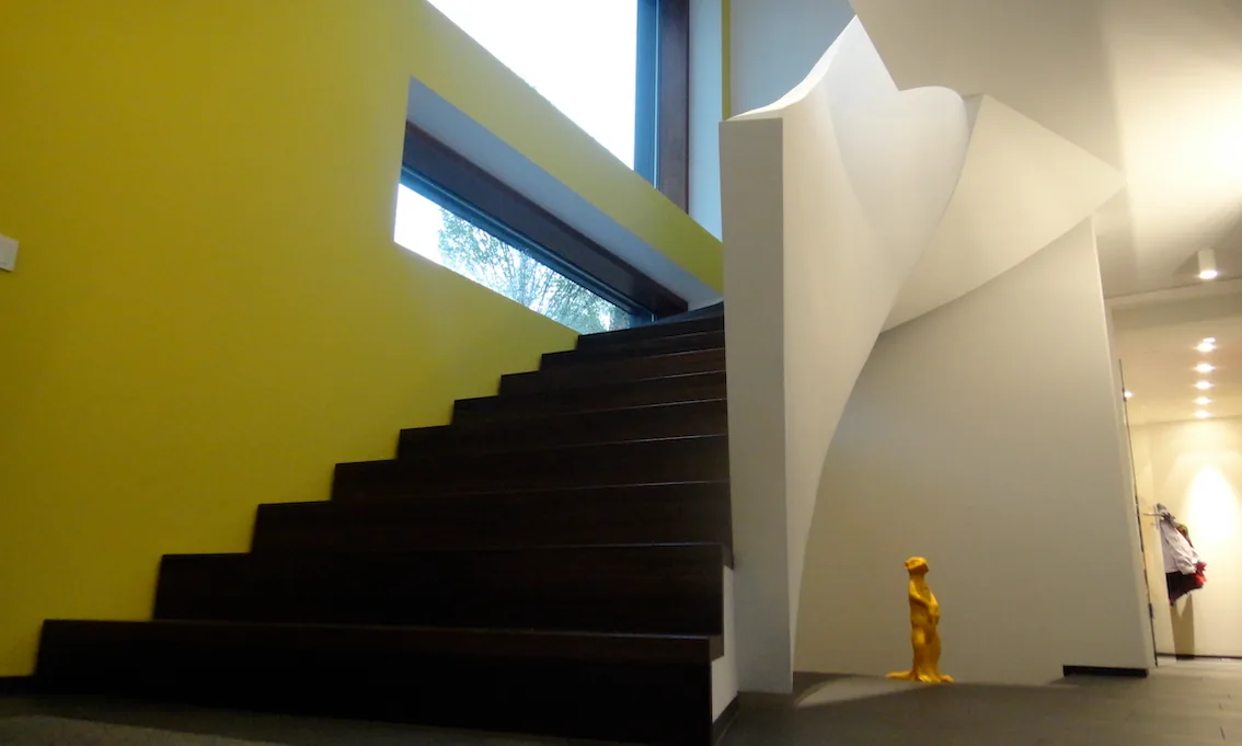 Treppe mit gelber Wand und gerundeter weisser Wand, Innenansicht