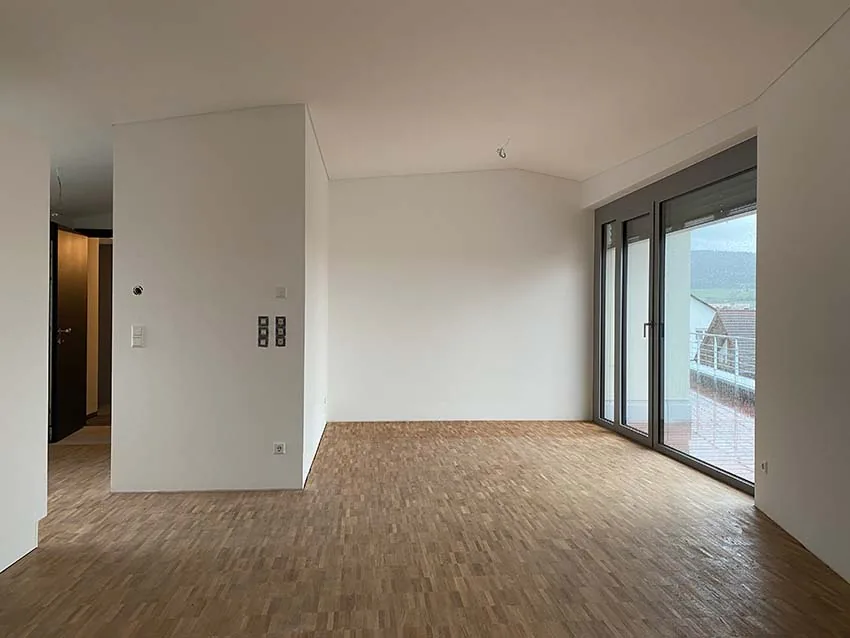 Leerer Wohnraum mit Fenstertür, Innenansicht