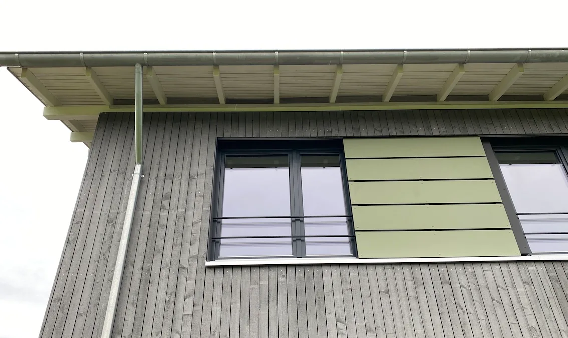 Holzfassade mit Fenstern und Dachüberstand, Detail